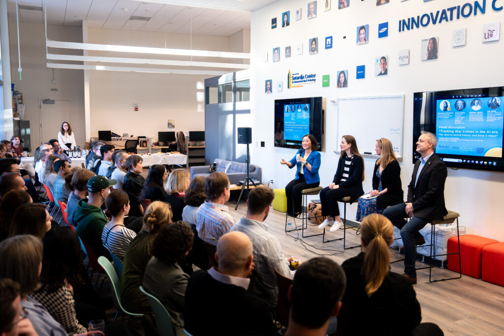 The four panelists face an audience of a few dozen people listening attentively to the discussion on the impact of AI on war crimes in Ukraine.