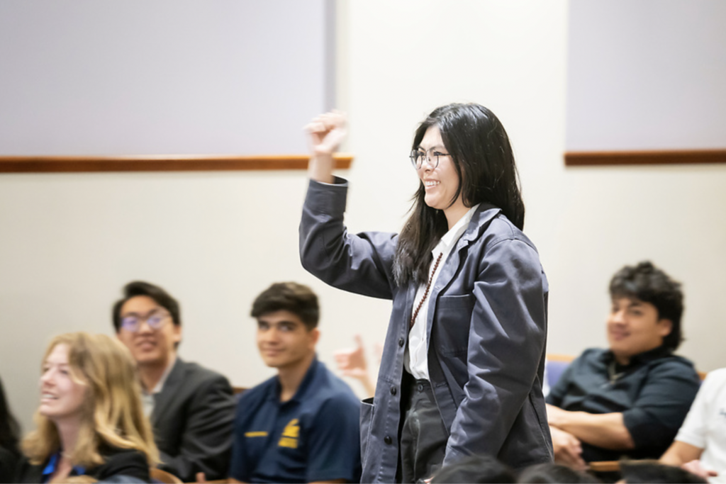 Kelly Chou holds up a hand in celebration while walking to stage to accept her Best Course Coordinator Award.